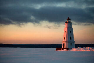 ashland wisconsin lighthouse on frozen chequamegon bay at sunset