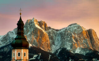 sunset in the italian dolomites with church steeple 