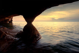 sunset across lake superior from inside a sea cave on devil's island in the apostle islands.