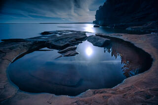 full moon rising and reflecting in a wave pool on devil's island in the apostle islands national lakeshore