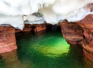 ice cave with green glowing water on devil's island in the apostle islands