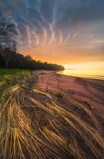 ironwood island sunrise with beach grass and colorful clouds in the apostle islands near bayfield wisconsin