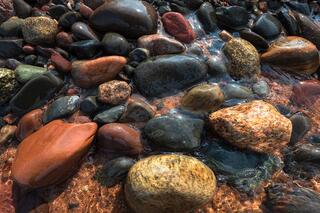 beach stones in water with evening light at ironwood island in the apostle islands