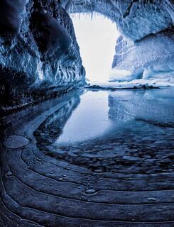ice cave on stockton islands in the apostle islands with frozen foreground pattern