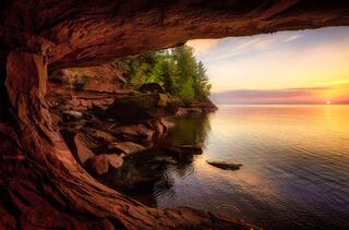 lake superior sunrise with a waterfall and sea cave on stockton island in the apostles