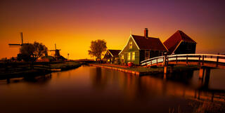 zaanse schans in the netherlands at sunset with windmills and water