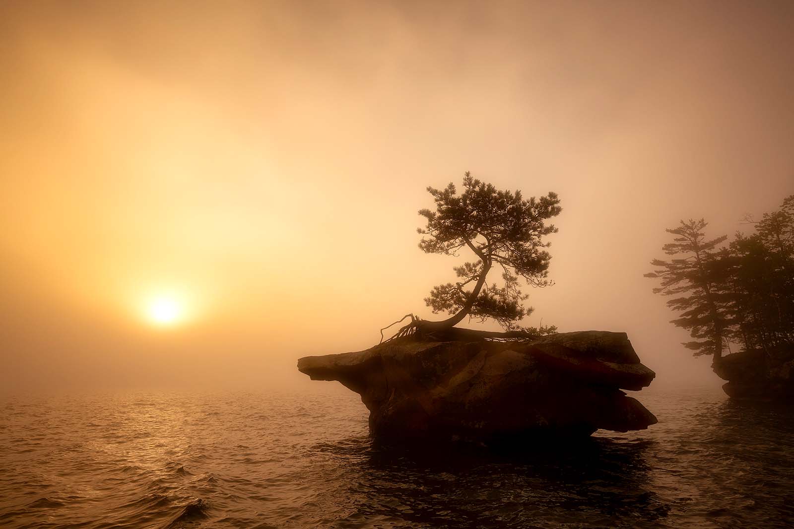 a foggy sunrise from honeymoon rock on basswood island in the apostle islands national lakeshore on lake superior wisconsin