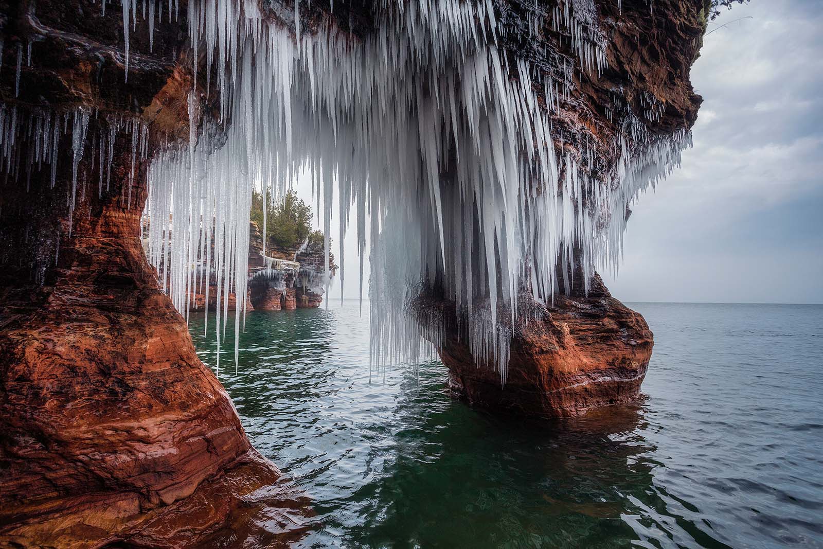 ice arch on devil's island with frozen cliff in the distance in the apostle islands of wisconsin