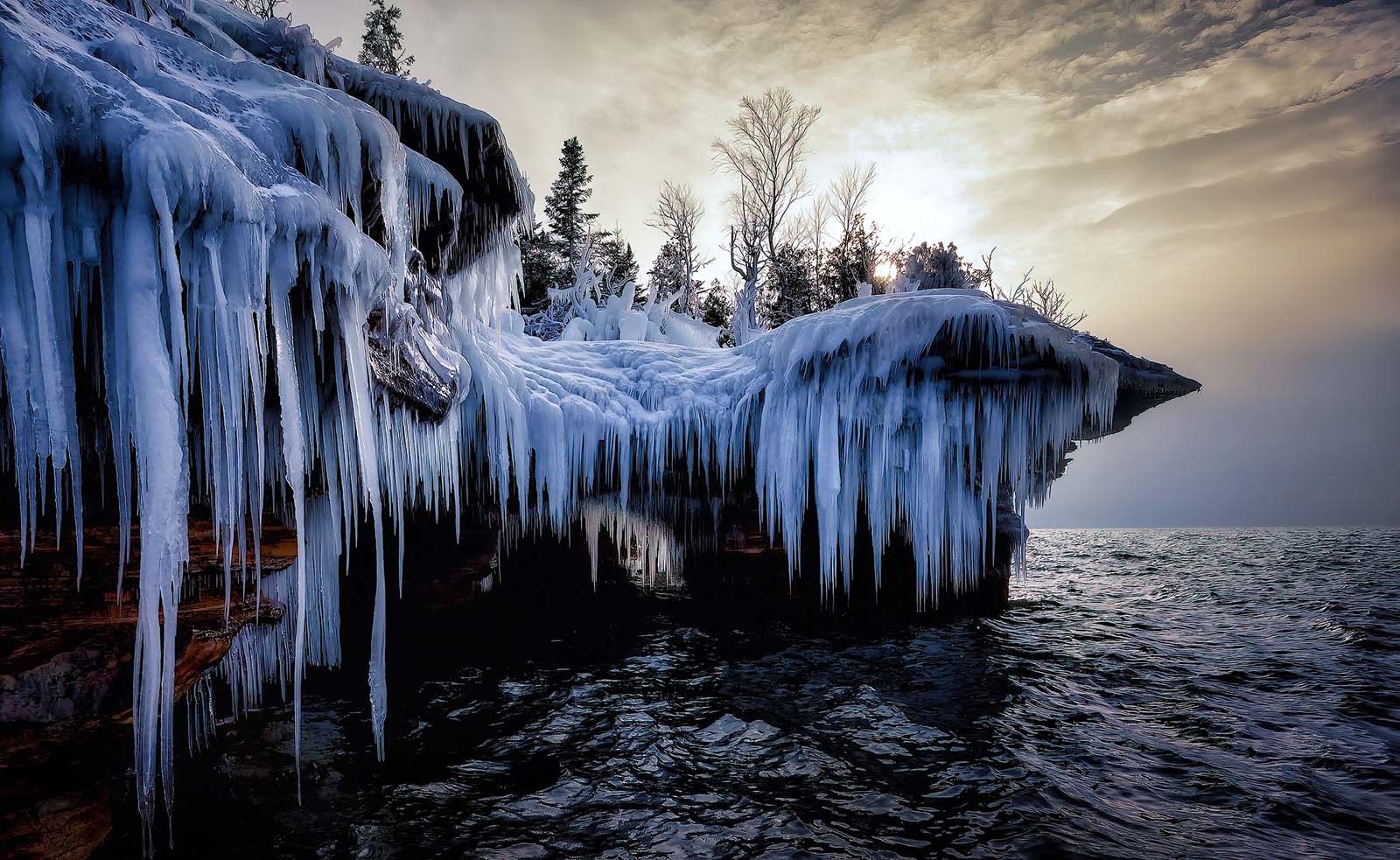 devil's island ice caves at sunset with glowing sky in the apostle islands