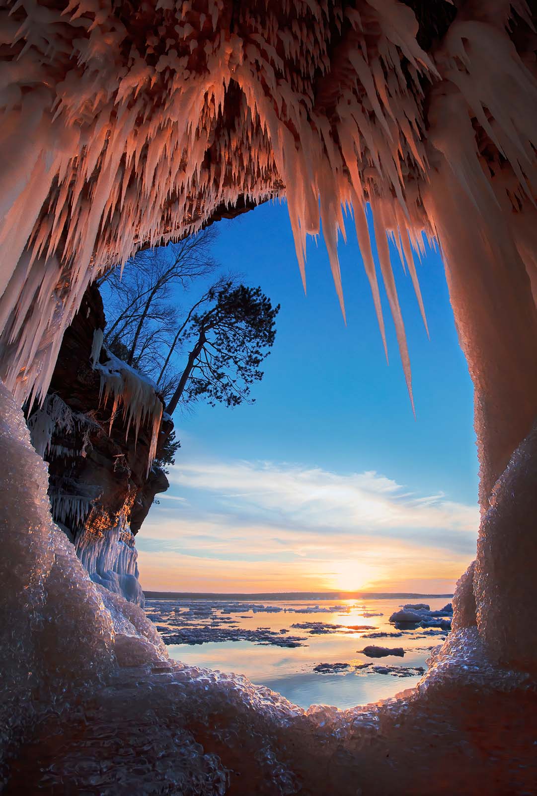 sunset through a porthole ice cave at the mainland ice caves in the apostle islands