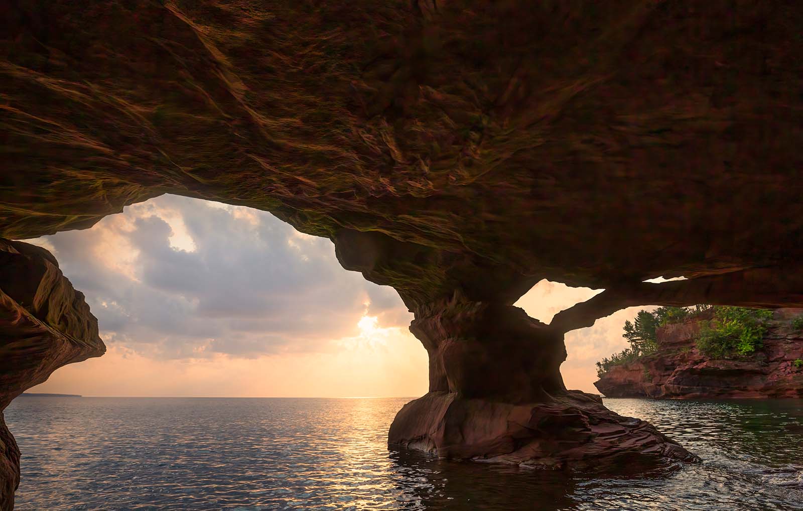 sunrise from inside a sea cave with amazing sandstone structure on stockton island in the apostles