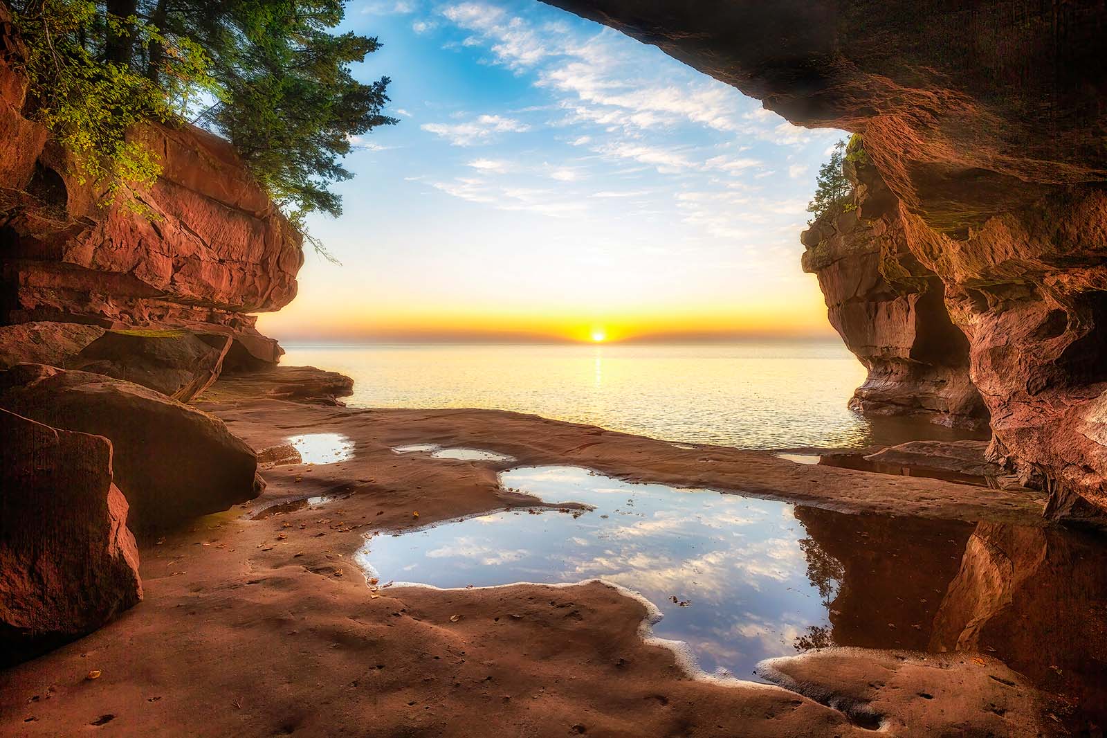 sunrise from a sandstone sea cave with small wave pools on stockton island in the apostle islands