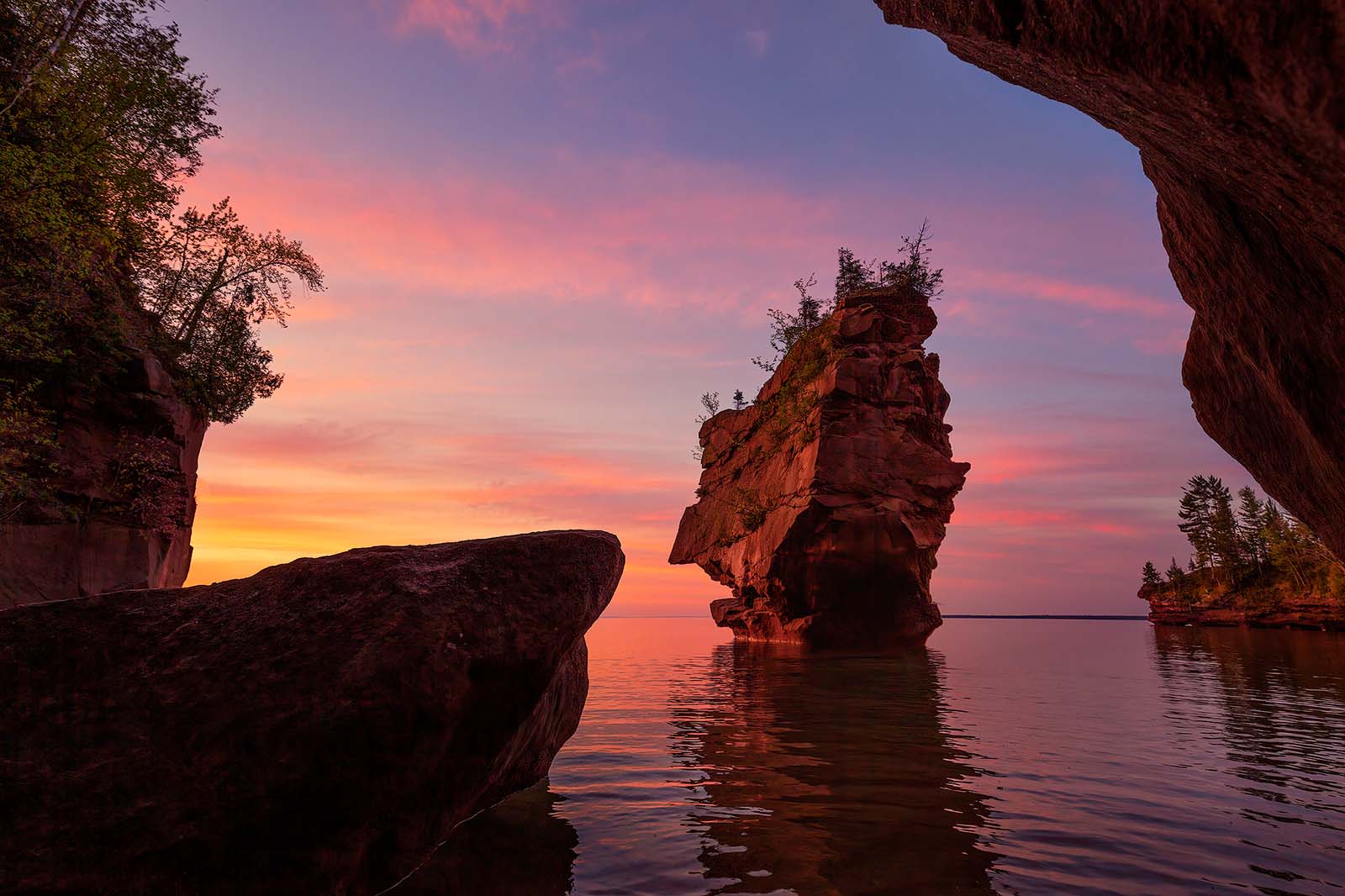 A sandstone sea stack under gorgeous skies during sunrise on stockton island in the apostle islands.